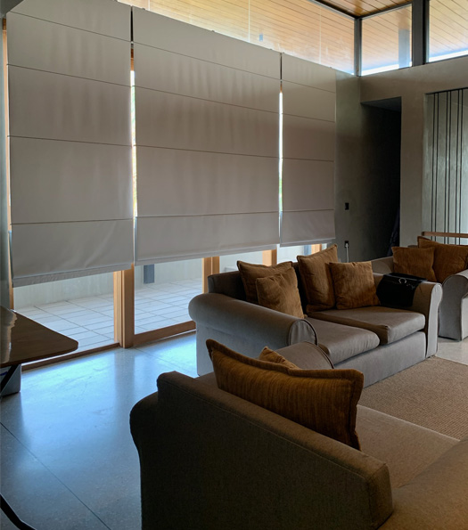 grey-roman-blinds-behind-brown-chairs